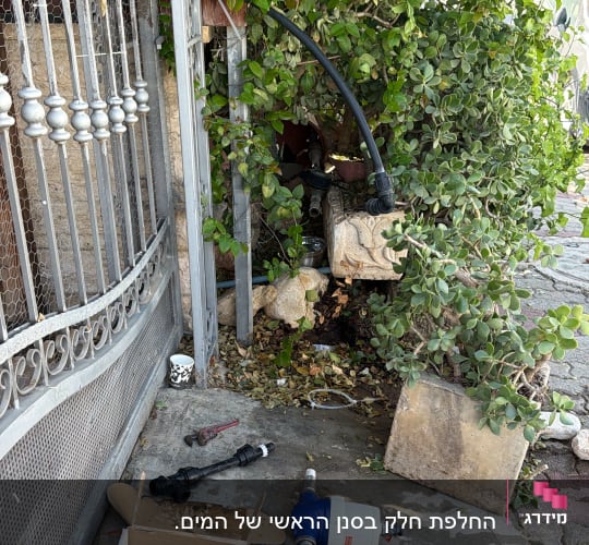 כלי עבודה ומסנן מים במהלך עבודת אינסטלציה בגינה